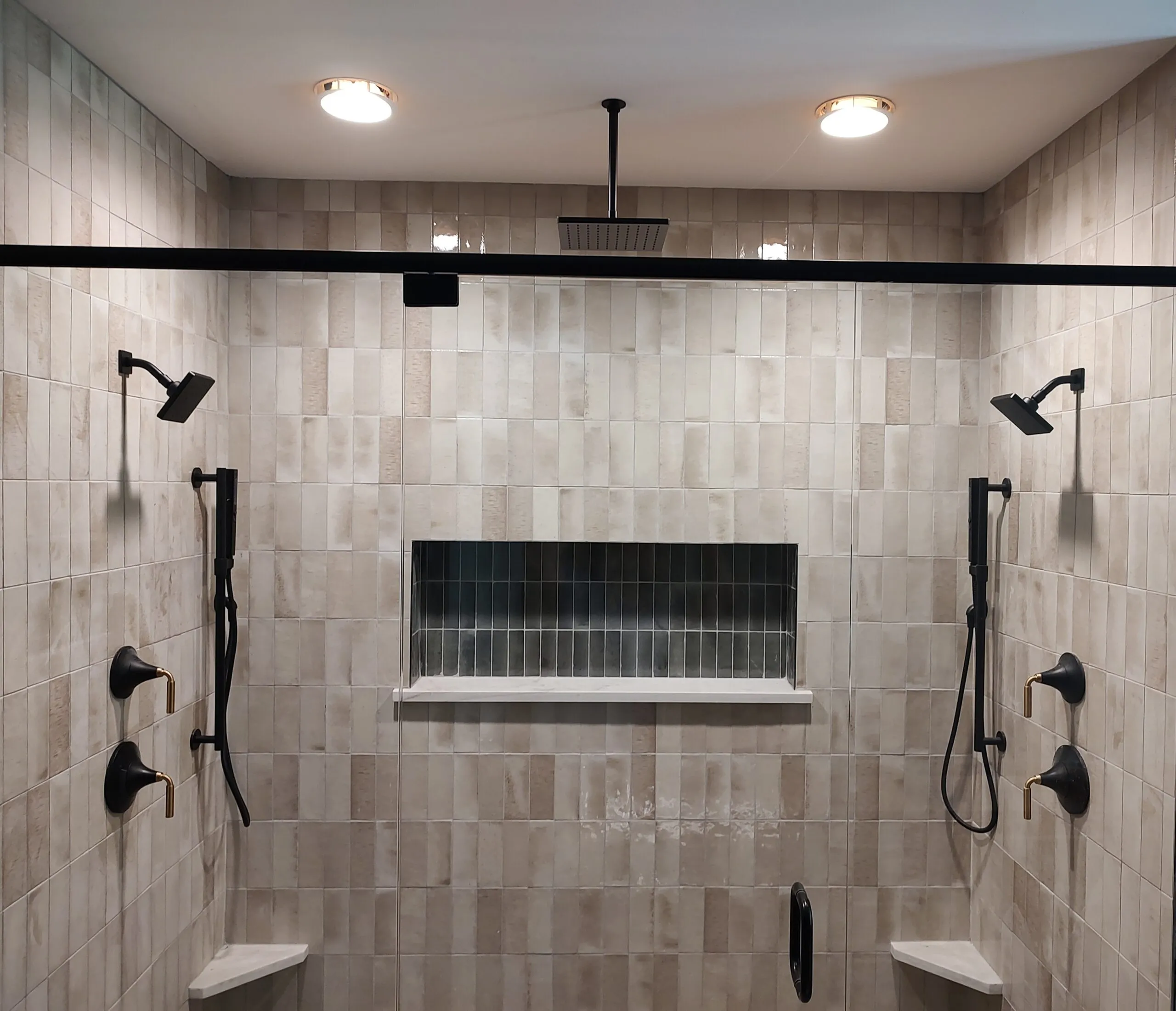 Double shower with two rain heads, body sprays and stacked stone look tile