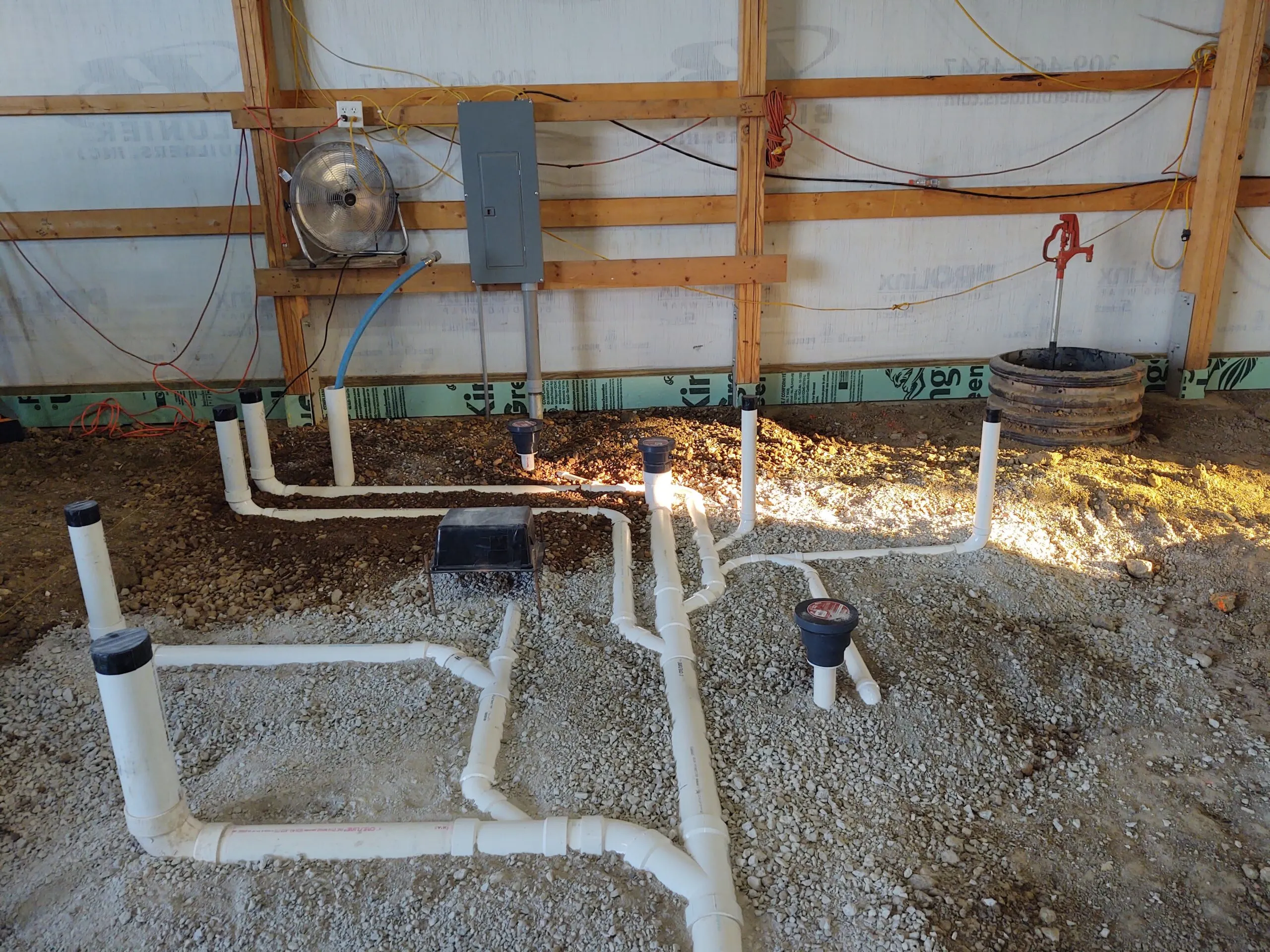 Basement rough-in with PVC waste lines, cleanouts and a water meter set