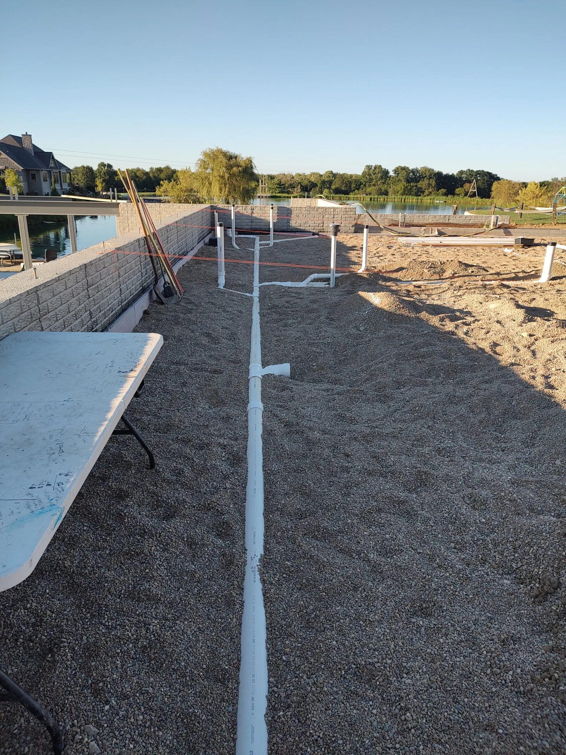 Underground water service run along a retaining wall at a lakeside property