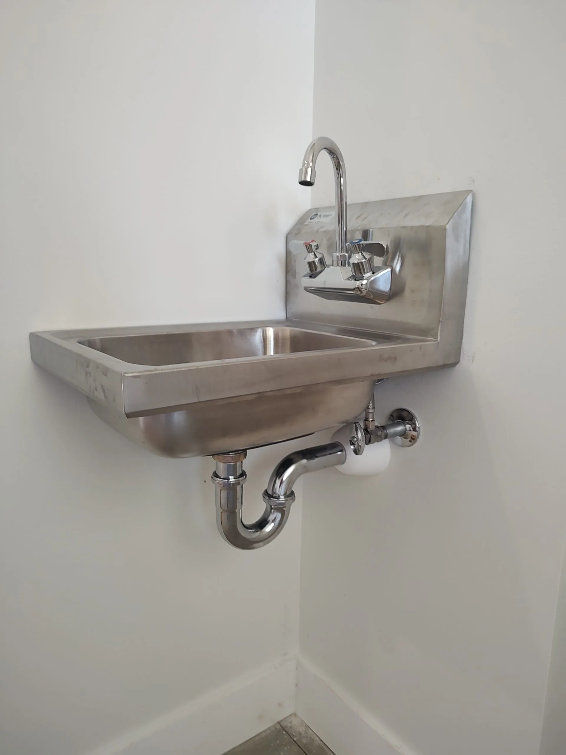 Stainless steel wall mount hand sink in a commercial kitchen